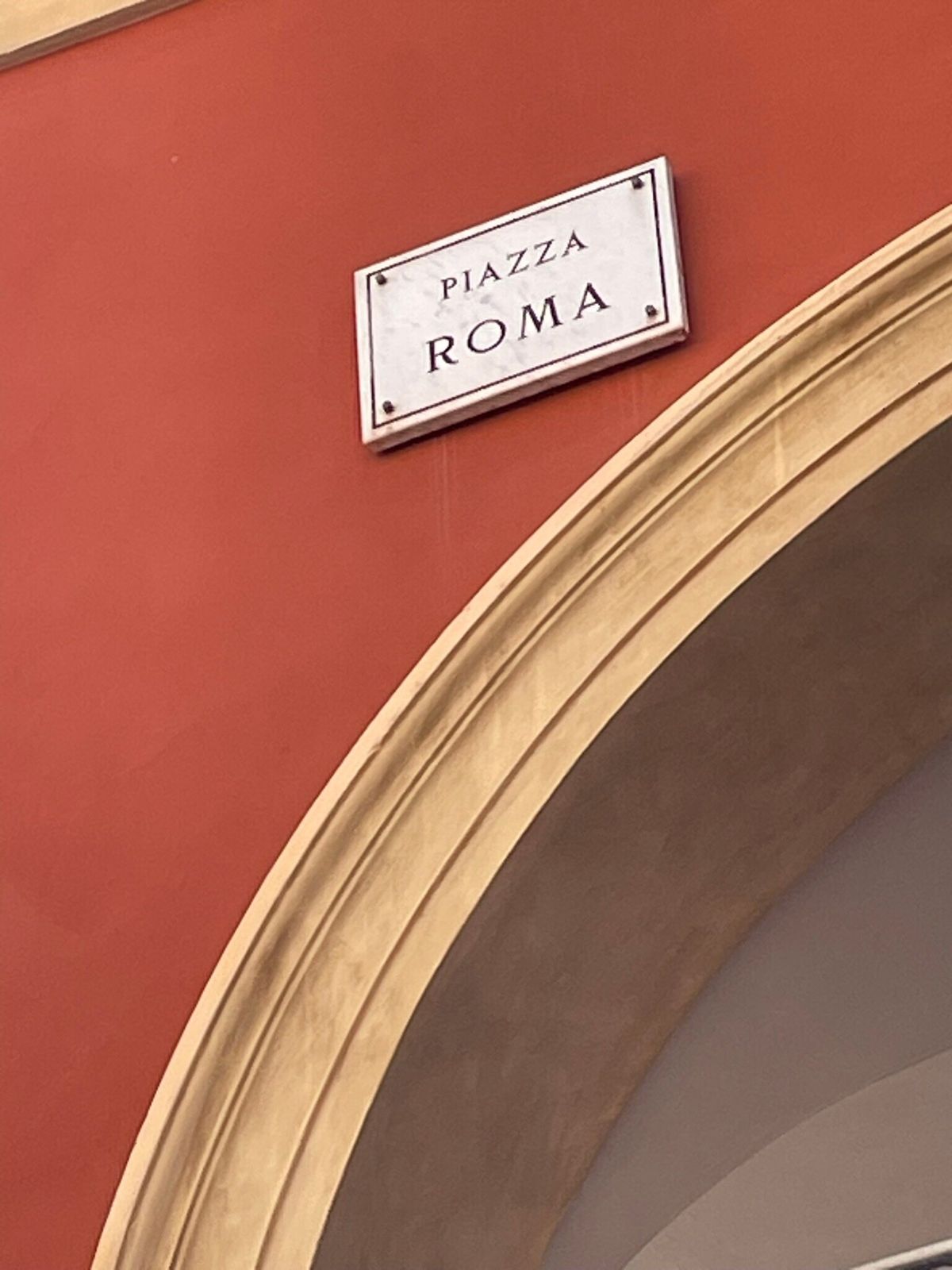 La targa smaltata Piazza Roma sul muro rosso mattone dell'edificio